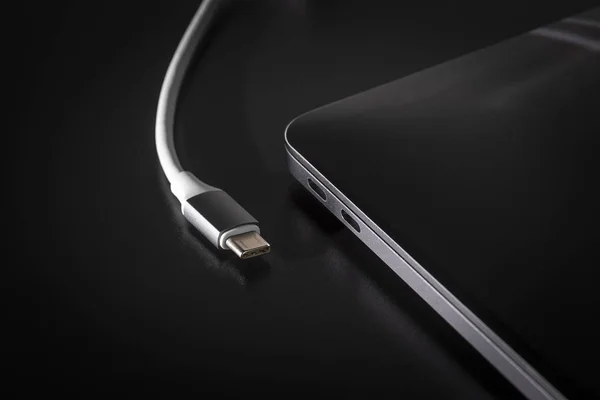 USB tipi C kablo siyah arka plan üzerine dizüstü bilgisayara bağlama