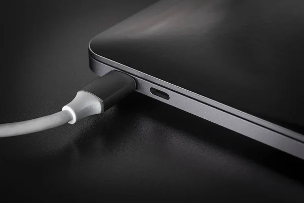 Dizüstü siyah arka plan üzerine bir beyaz Usb tip C kablosu bağlı
