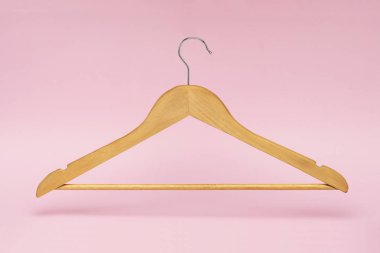Ahşap elbise askısı izole ve pembe bir arka plan üzerinde gölgeni