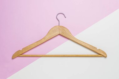 Pembe ve beyaz arka plan üzerinde izole ahşap bir elbise askısı