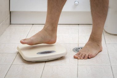 Banyoda yerde ağırlık ölçekler üzerinde adım adam ayak kırpılmış görüntü