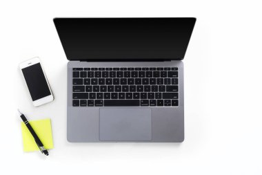 Masa laptop, cep telefonu, kalem ile görünümünü üst ve beyaz arka plan üzerinde izole notlar sonrası