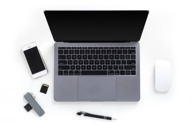 Masa laptop, cep telefonu, bellek kartları, kart okuyucu, kalem ve beyaz arka plan üzerinde izole fare ile üstten görünüm