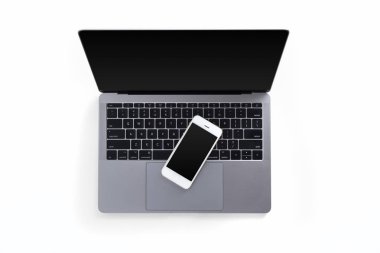 Masa üstü dizüstü bilgisayar ve cep telefonu beyaz arka plan üzerinde izole üstten görünüm