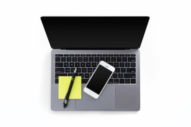 Masa laptop, cep telefonu, kalem ile görünümünü üst ve beyaz arka plan üzerinde izole notlar sonrası