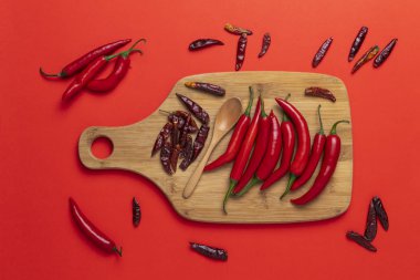 Kırmızı biber biber, kırmızı zemin üzerine Ahşap Doğrama tahtası üzerinde kurutulmuş Asya sıcak kırmızı biber grupları