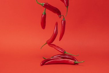 Kırmızı dar uzun baharatlı kırmızı zemin üzerine düşme biber görüntüsünü