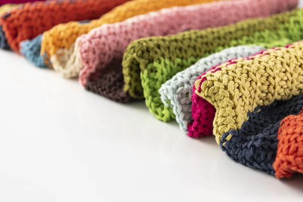 Wool blanket, colorful, knitted large chunky yarn. Close-up of knitted blanket on white background.