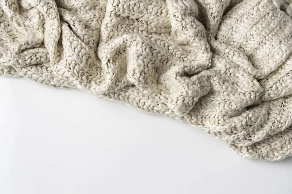 Wool blanket, white, knitted large chunky yarn. Close-up of knitted blanket on white background.
