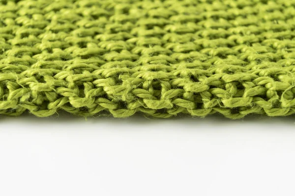 Wool blanket, green, knitted large chunky yarn. Close-up of knitted blanket on white background.