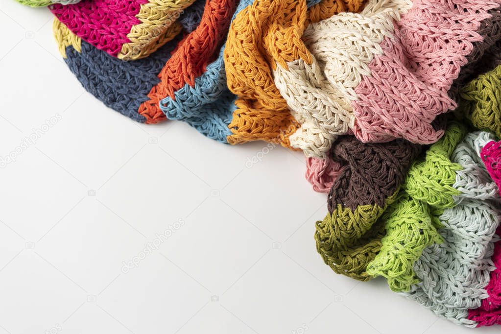 Wool blanket, colorful, knitted large chunky yarn. Close-up of knitted blanket on white background.