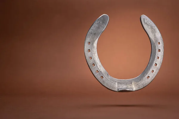 Levitating Horseshoe Isolated Brown Background Copy Space — Stock Photo, Image