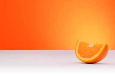 A piece of orange isolated on an orange and white background with space for text clipart
