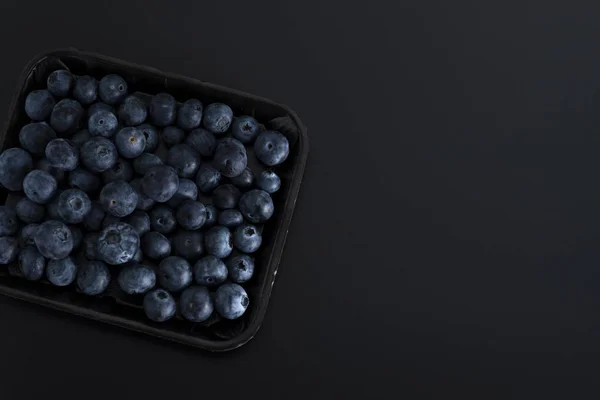 Bund Blauer Beeren Auf Einem Tablett Isoliert Auf Schwarzem Hintergrund — Stockfoto