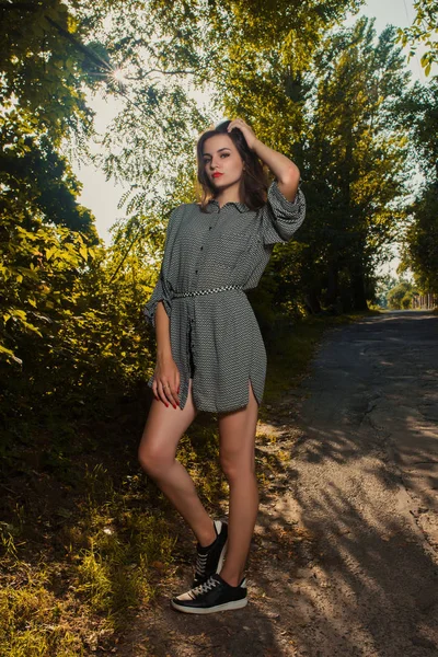 Trendy giyim bir yeşil ağaç arka plan üzerinde poz sihir esmer kız