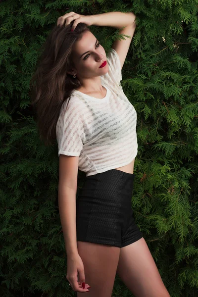 Esmer kız trendy uzun gömlekli bir yeşil Mazı arka plan üzerinde poz şaşırtıcı