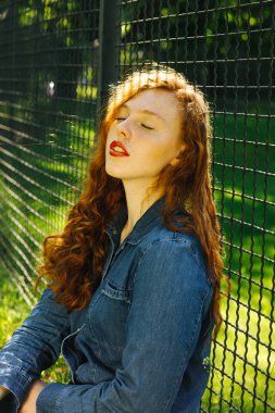 Closeup sokak portre sevimli kırmızı saçlı Genç kadının güneş parlamayı poz