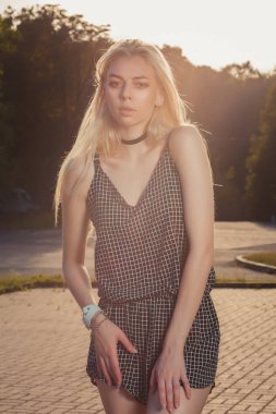 Uzun saç giyen ile muhteşem tabaklanmış sarışın kız siyah romper, Güneş parlamayı poz