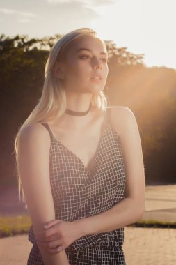 Portre portre siyah romper, güneş ışınlarının şehirde poz içinde çekici sarışın kadın