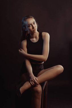 Stüdyo fotoğraf oturumu için bir genç güzel model siyah giyim giymiş gölgelerin içinde poz