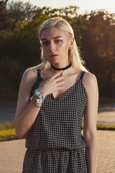 Siyah romper, güneş ışınlarının şehirde poz içinde oldukça tabaklanmış sarışın Bayan