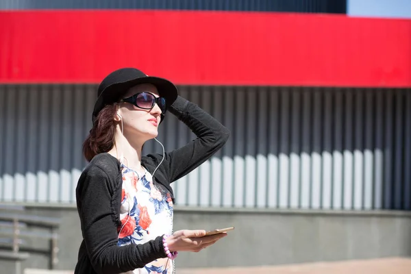 매력적인 모자와 선글라스 그녀의 전화에 텍스트를 — 스톡 사진