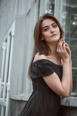 Sera poz çıplak omuz ile siyah elbise giyen romantik esmer kadın