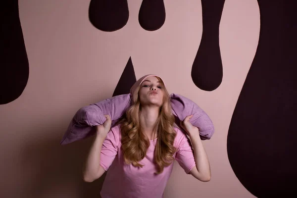 ピンクのスタジオの背景の上に枕で遊んで楽しい幸せな金髪女 — ストック写真