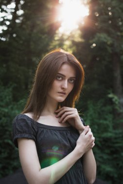 Siyah elbise giymiş, günbatımında parkta poz güzel esmer modeli