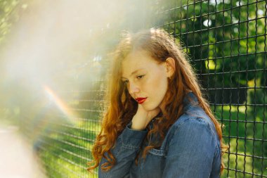 Güzel kırmızı saçlı Genç kadın güneş parlamayı poz sokak portresi. Metin için yer