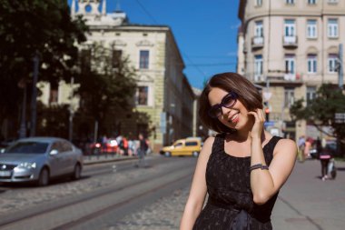 Model giyen moda elbise ve şehir sokaklarda yürüyen gözlük gülümseyen klas. Metin için yer