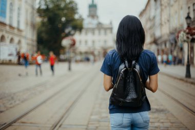 Genç kadın turist ile eski bir şehir Lviv yürüyüş bir deri sırt çantası. Metin için yer