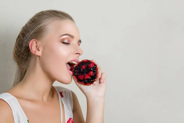 Mooie Jonge Blonde Vrouw Bijten Een Zoete Cupcake Met Bessen — Stockfoto