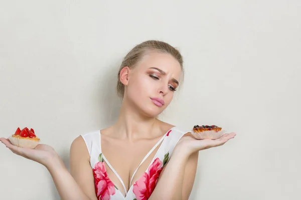 Mulher Loira Dieta Perturbada Olhando Sobremesas Creme Doce Suas Mãos — Fotografia de Stock