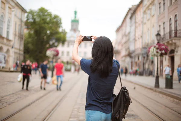 バックパックをスマート フォンの市内中心部や撮影写真を歩いて観光します テキストのためのスペース — ストック写真