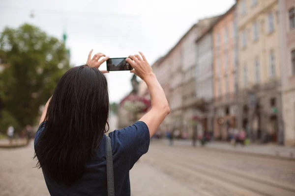 游客穿过市中心 在她的手机上拍照 空空间 — 图库照片