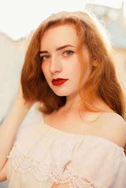 Güzel kırmızı saçlı bir kadınla şehir sokak poz çıplak omuz portre çekim