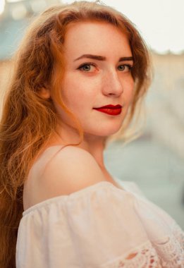 Güzel kırmızı saçlı bir kadınla şehir sokak poz çıplak omuz portre çekim