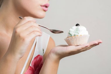 Çekici sarışın model tereyağı krema ile lezzetli tatlı tatlı yeme. Closeup çekim