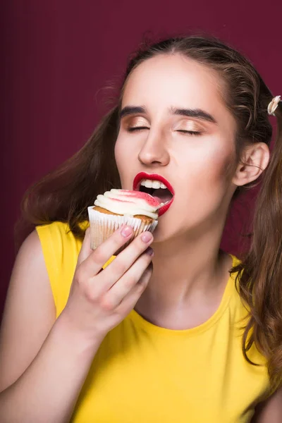 Hambrienta Morena Mordiendo Delicioso Pastel Con Crema Sobre Fondo Rojo — Foto de Stock