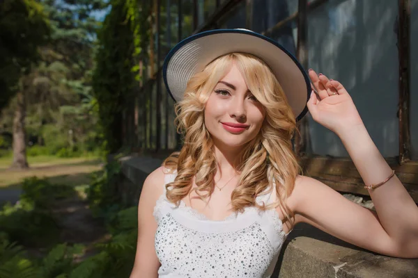 Şapka ve sera poz modaya uygun kıyafet giyen neşeli sarışın kadın. Boş alan