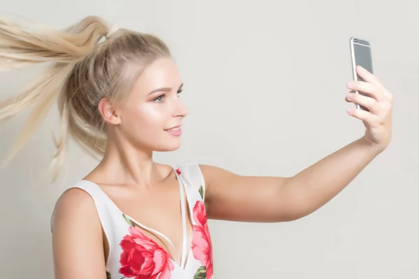 Pleased Blonde Girl Hair Motion Making Selfie Mobile Phone Grey — Stock Photo, Image