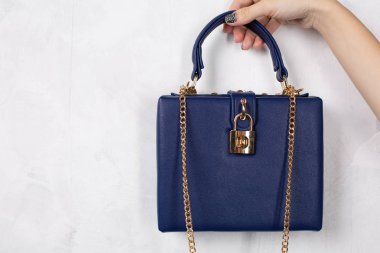 Mavi deri çanta altın zinciri ile tutarak el. Boş alan