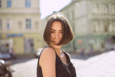 Sokakta yürürken bronz ten rengi ve doğal makyaj ile neşeli esmer kadın. Boş alan