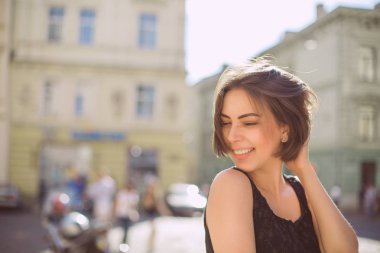 Sokakta yürürken bronz ten rengi ve doğal makyaj ile neşeli esmer kadın. Boş alan