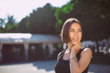 Sokakta yürürken bronz ten rengi ve doğal makyaj ile neşeli esmer kadın. Boş alan