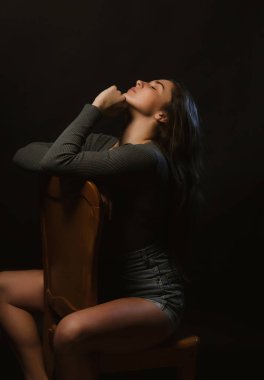 Gri iç çamaşırı ve kot şort giymiş modeli testler sırasında stüdyoda oturan ihale esmer kadın