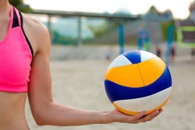 Karşı plaj voleybol topu tutan güzel atletik kadın. Metin için yer