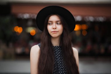 Esmer modeli şapka ve şehrin ışıkları ile sokak, poz vintage elbise giyen şaşırtıcı 