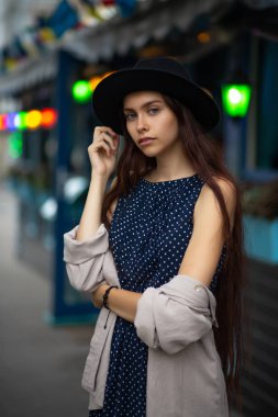 Şehrin ışıkları ile sokak, poz harika esmer modeli giyiyor şapka ve vintage elbise 